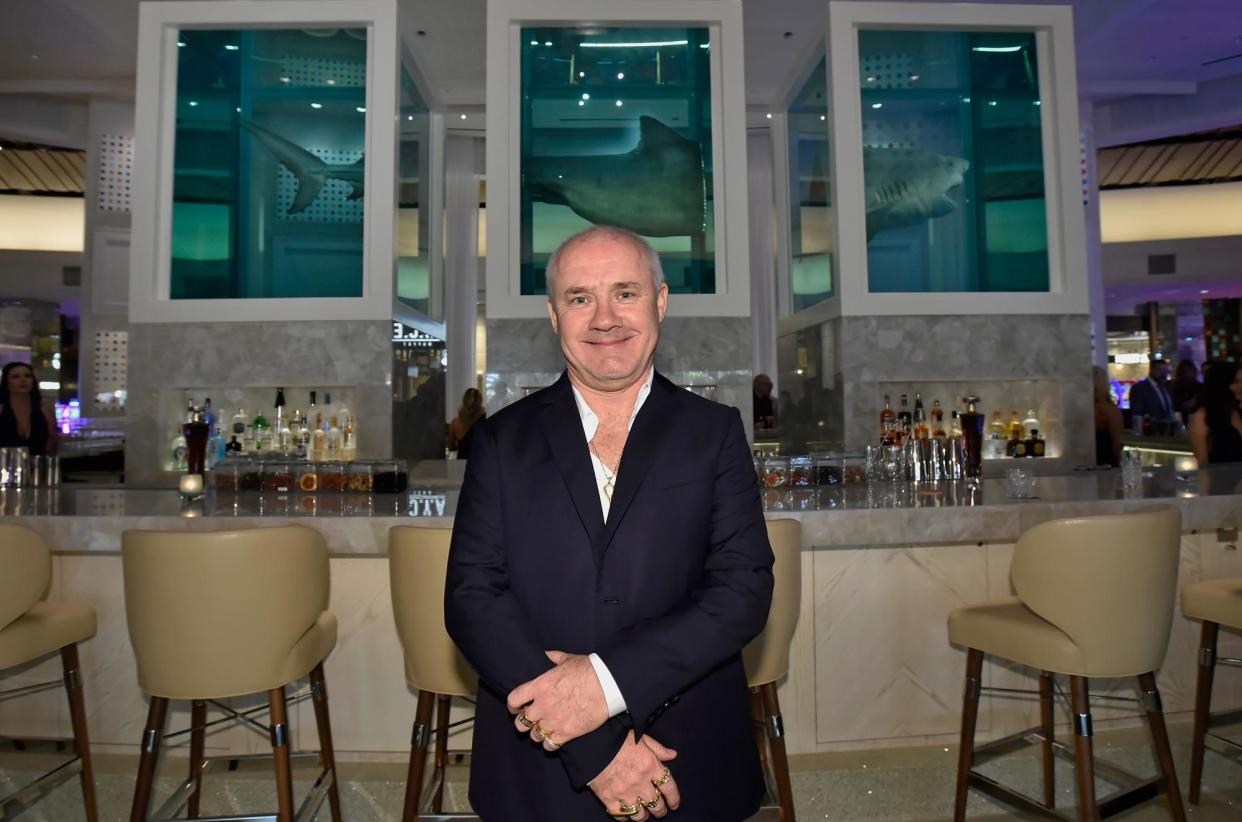 <span>Damien Hirst in front of the shark sculpture during a party at the Palms casino resort in Las Vegas in 2018.</span><span>Photograph: David Becker/Getty Images for Palms Casino Resort</span>