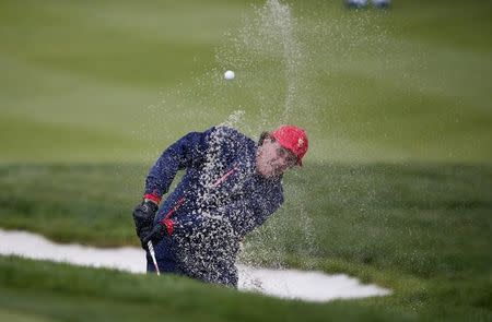 U.S. team Phil Mickelson hits out of a bunker on the first hole during their singles matches of the 2015 Presidents Cup golf tournament at the Jack Nicklaus Golf Club in Incheon, South Korea, October 11, 2015. REUTERS/Kim Hong-Ji