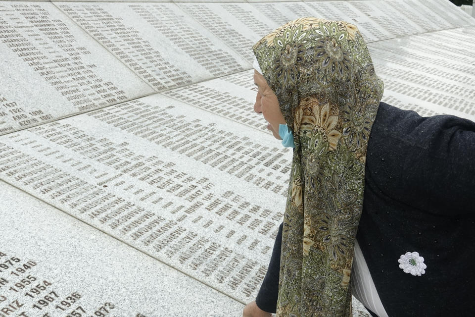 Djulija Jusic who lost her two sons and the 33 relatives in Srebrenica massacre looks at names at the memorial cemetery in Potocari near Srebrenica, Bosnia, Friday, May 28, 2021. U.N. judges on Tuesday, June 8 deliver their final ruling on the conviction of former Bosnian Serb army chief Radko Mladic on charges of genocide, war crimes and crimes against humanity during Bosnia’s 1992-95 ethnic carnage. Nearly three decades after the end of Europe’s worst conflict since World War II that killed more than 100,000 people, a U.N. court is set to close the case of the Bosnian War’s most notorious figure. (AP Photo/Eldar Emric)
