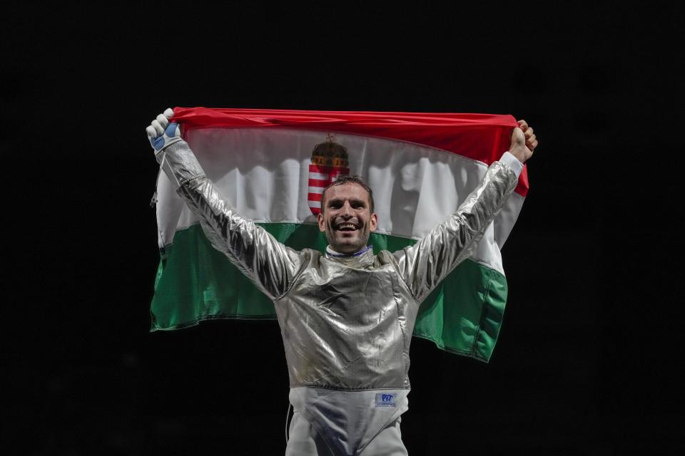 Aron Szilagyi of Hungary celebrates with his national flag after winning the gold in the men's individual final Sabre competition at the 2020 Summer Olympics, Saturday, July 24, 2021, in Chiba, Japan. (AP Photo/Andrew Medichini)