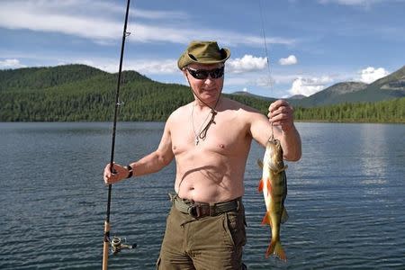 Russian President Vladimir Putin holds a fish he caught during the hunting and fishing trip which took place on August 1-3 in the republic of Tyva in southern Siberia, Russia, in this photo released by the Kremlin on August 5, 2017. Sputnik/Alexei Nikolsky/Kremlin via REUTERS