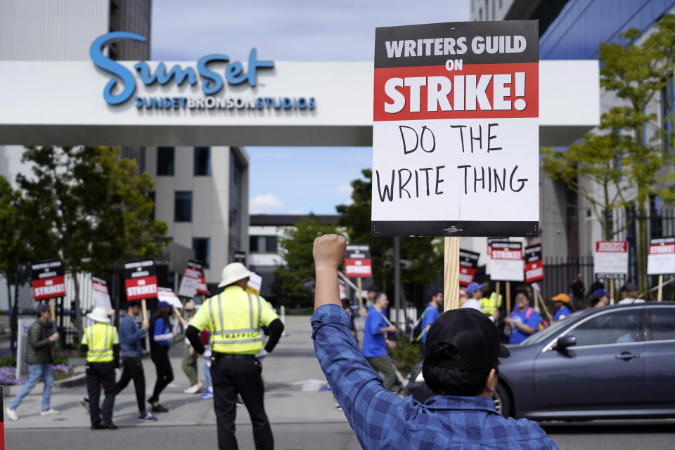 A demonstrator holds up a protest sign outside of Netflix offices on day two of a strike by the Writers Guild of America, Wednesday, May 3, 2023, in Los Angeles. Television and movie writers launched a strike Tuesday for the first time in 15 years, as Hollywood girded for a walkout with potentially widespread ramifications in a fight over fair pay in the streaming era. (AP Photo/Chris Pizzello)