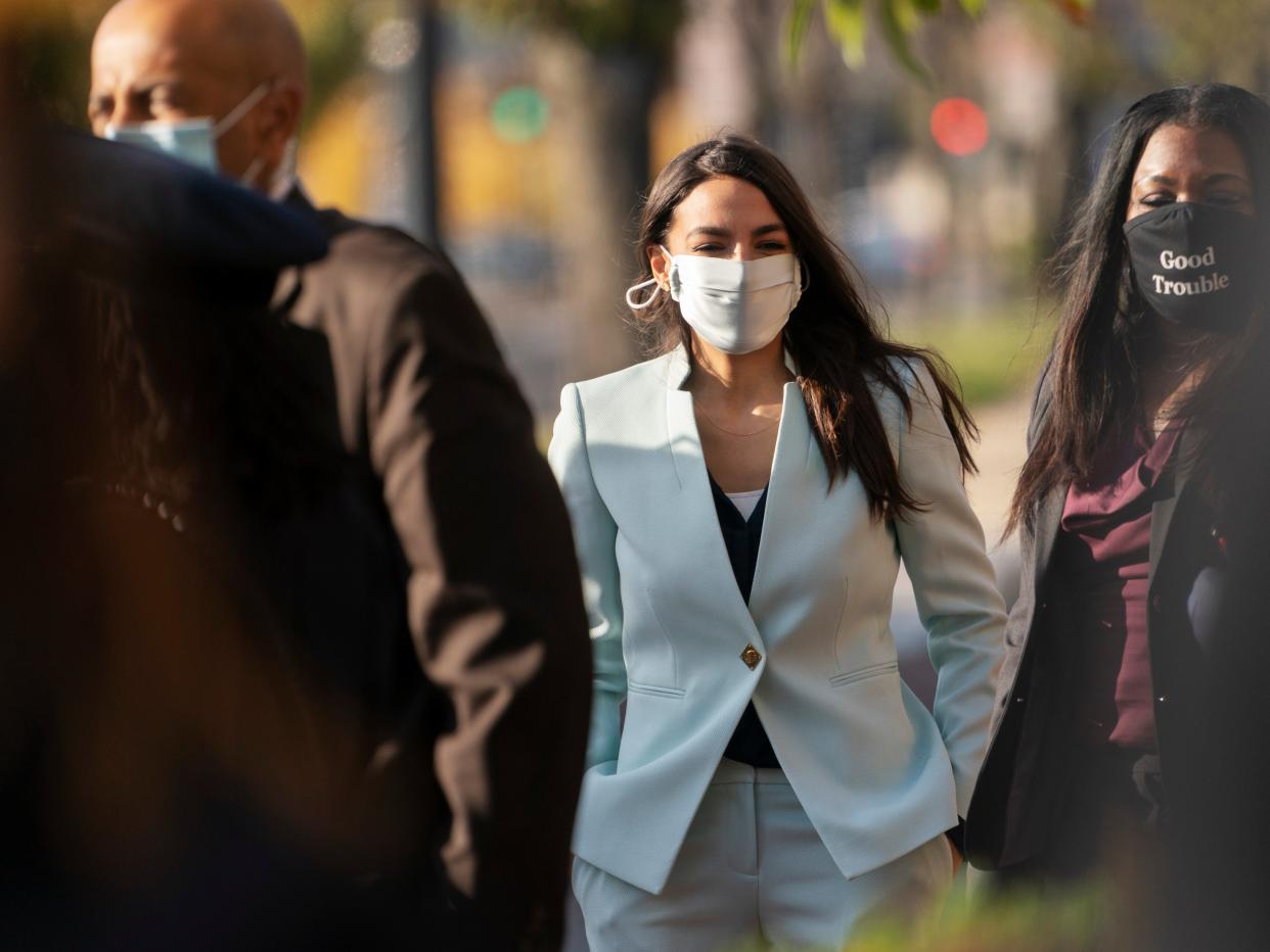 Rep Alexandria Ocasio-Cortez, center, arrives for an event with Rep.-elect Cori Bush, right on Thursday, 19 November 2020, outside the Democratic National Committee (AP)