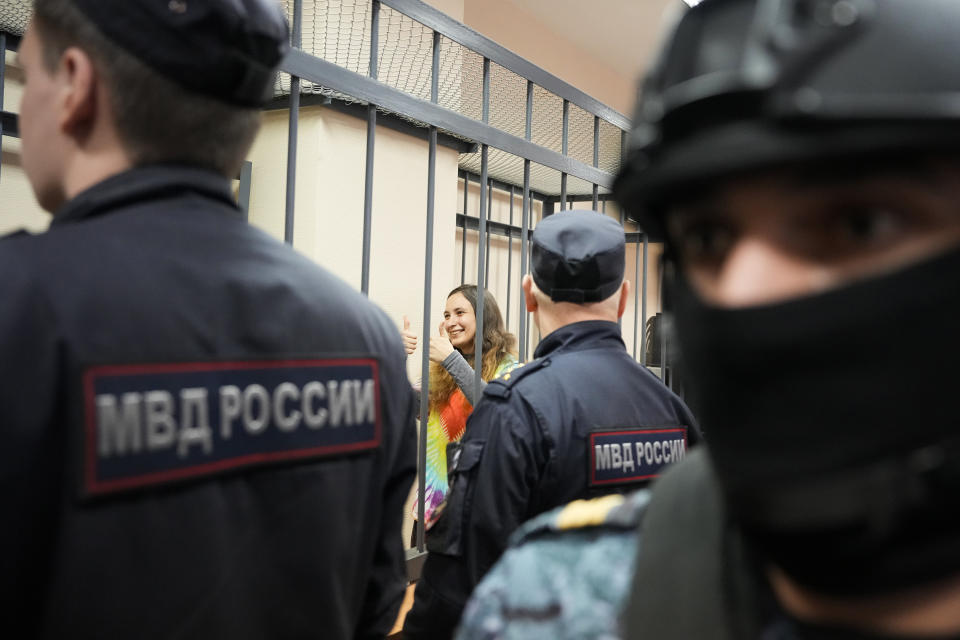 Sasha Skochilenko, a 33 year-old artist and musician reacts standing behind bars in the court room in the Vasileostrovsky district court in St. Petersburg, Russia, Thursday, Nov. 16, 2023. Skochilenko has been convicted of spreading false information about the military and sentenced to 7 years in prison after replacing several supermarket price tags with slogans criticizing Russia's military action in Ukraine. (AP Photo/Dmitri Lovetsky)