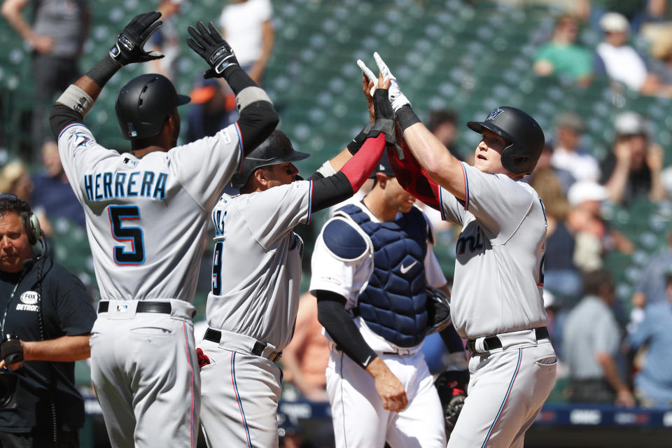 Miami Marlins' Garrett Cooper, right, celebrates with teammates after hitting a grand slam in the ninth inning of a baseball game against the Detroit Tigers in Detroit, Thursday, May 23, 2019. (AP Photo/Paul Sancya)