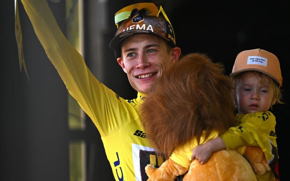 Jonas Vingegaard in the Tour de France yellow jersey, holding his sun and a lion cuddly toy