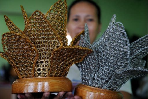 A worker holds up lampshades made with push-tabs from aluminum beverage cans that sell for $90 each at the Philippine Christian Foundation in Manila. "I thought, why not make garbage into something we can profit from," Jane Walker said. "And that's how it began."