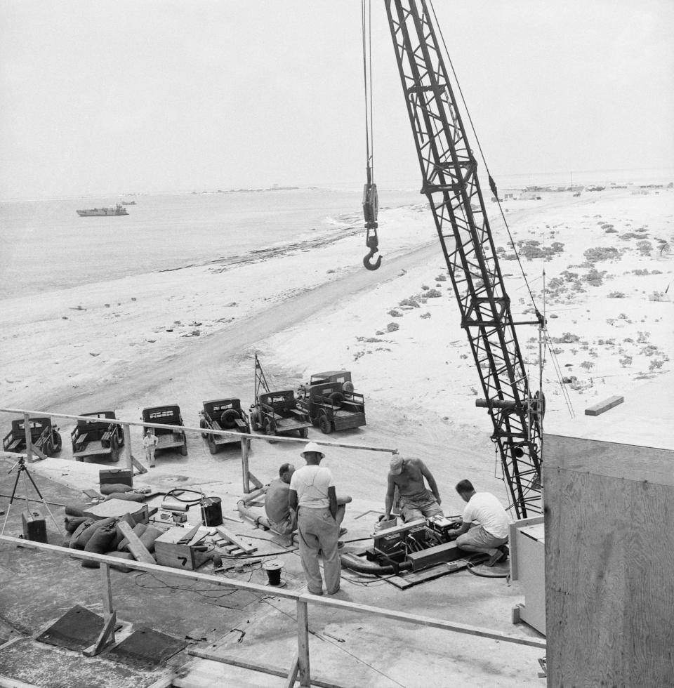 Scientific photo personnel are shown atop a big concrete bunker near "ground zero," over which a B-52 will drop a hydrogen bomb at the AEC's proving ground in Eniwetok on May 9, 1956..