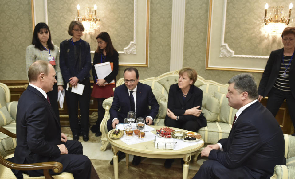 FILE - From left, Russian President Vladimir Putin, French President ,Francois Hollande, German Chancellor, Angela Merkel, and Ukrainian President, Petro Poroshenko, talk in Minsk, Belarus, Feb. 11, 2015. A peace agreement for eastern Ukraine has remained stalled for years, but it has come into the spotlight again amid a Russian military buildup near Ukraine that has fueled invasion fears. On Thursday, Feb. 10, 2022 presidential advisers from Russia, Ukraine, France and Germany are set to meet in Berlin to discuss ways of implementing the deal that was signed in the Belarusian capital of Minsk in 2015. (Mykola Lazarenko/Pool Photo via AP, File)
