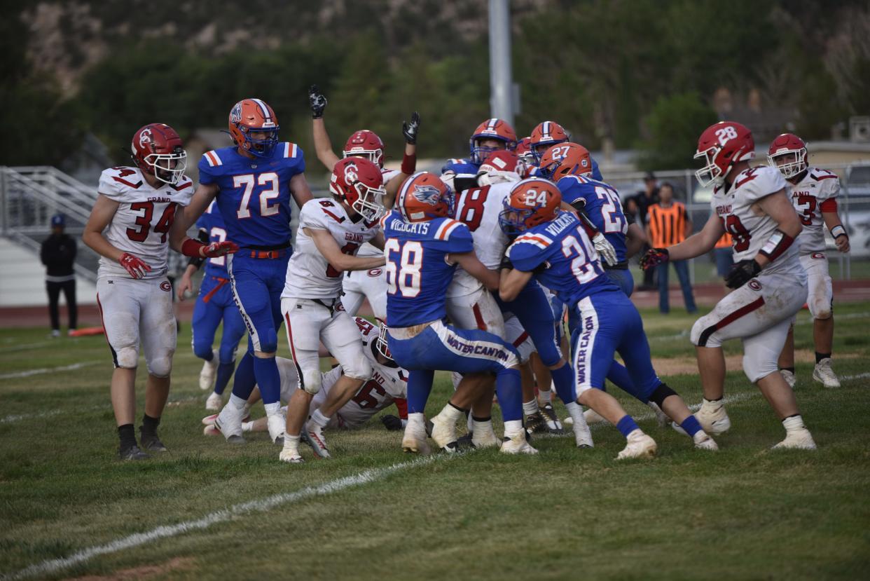 Water Canyon's defense swarms Grand County quarterback Tatym Bisco on Friday night.