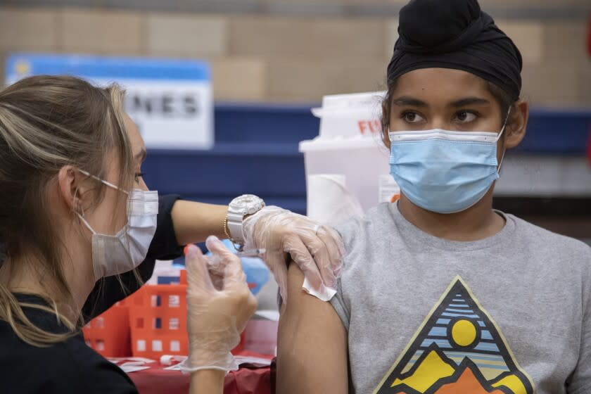 ARLETA, CA - NOVEMBER 08: Harnoorvir Singh Jabbal (cq), 11, gets the COVID-19 vaccine from nurse Chelsea Meyer at Arleta High School on Monday, Nov. 8, 2021. Following the recent Centers for Disease Control and Prevention's approval of Pfizer's COVID-19 vaccine for children ages 5 to 11, Los Angeles Unified will offer voluntary vaccine access to students. The district highly encourages the vaccine for children ages 5 to 11, however, it will not be part of Los Angeles Unified's current student vaccine requirement. (Myung J. Chun / Los Angeles Times)