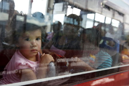 A girl looks out of the window of a bus, while she crosses the Simon Bolivar bridge on the border with Colombia with her relatives, at San Antonio in Tachira state, Venezuela, August 26, 2015. REUTERS/Carlos Garcia Rawlins