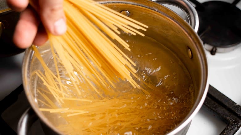 adding pasta to boiling water