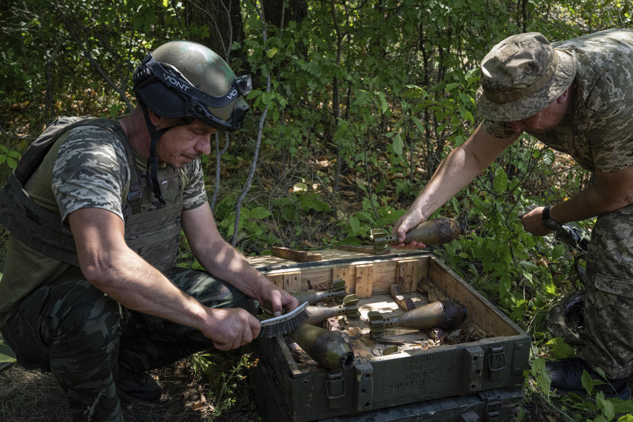 Ukrainian servicemen clean mortar shells during training in Kharkiv region, Ukraine, Tuesday, July 19, 2022. (AP Photo/Evgeniy Maloletka)