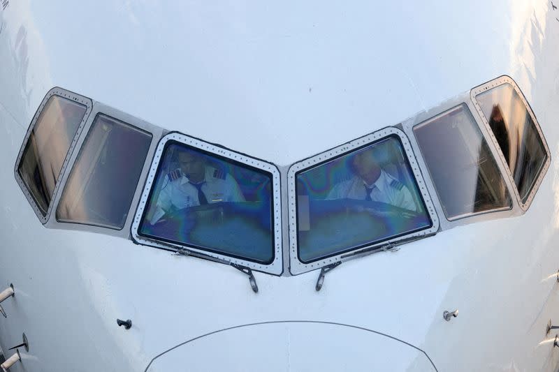 Pilots are seen in the cockpit of an airplane as it sits on the tarmac at John F. Kennedy International Airport on the July 4th weekend in Queens, New York City