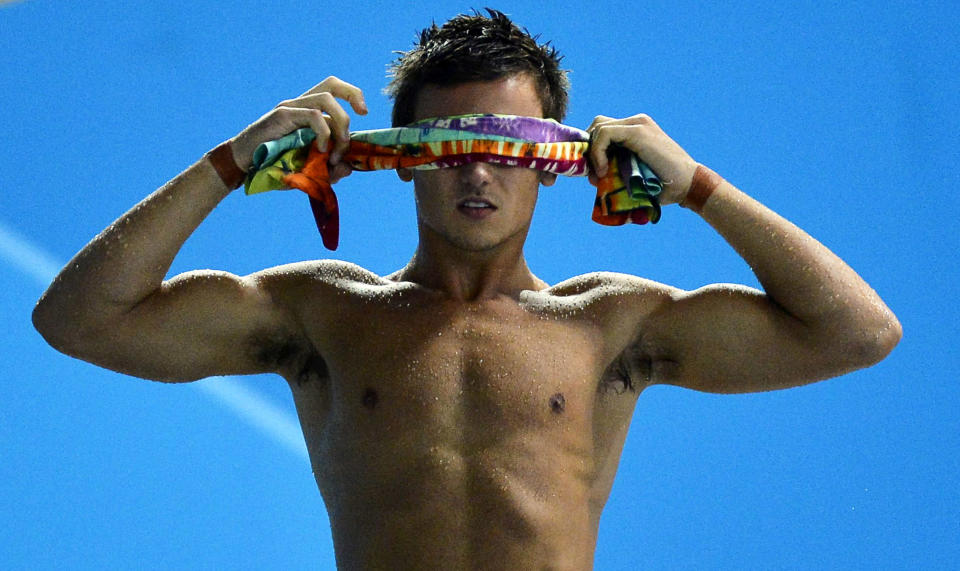 Britain's Tom Daley wraps a towel around his eyes in between dives in the men's synchronised 10m platform final during the London 2012 Olympic Games at the Aquatics Centre July 30, 2012. REUTERS/Toby Melville (BRITAIN - Tags: SPORT OLYMPICS SPORT DIVING)