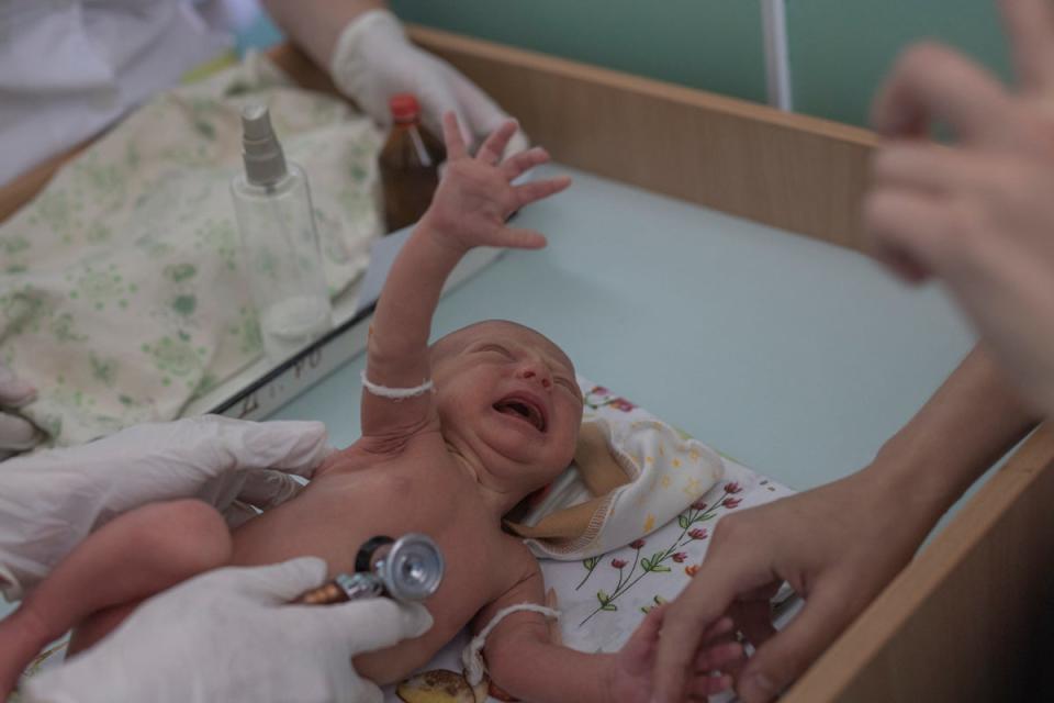 Marina Tupata watches as her six-day-old baby, Sofia, is examined (Reuters)