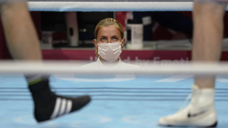 <p>A masked ring side official watches as Azerbaijan's Mahammad Abdullayev, right, and Bahrain's Danis Latypov compete in a men's super heavyweight over 91-kg boxing match at the 2020 Summer Olympics in Tokyo, Japan. (AP Photo/David Goldman)</p> 