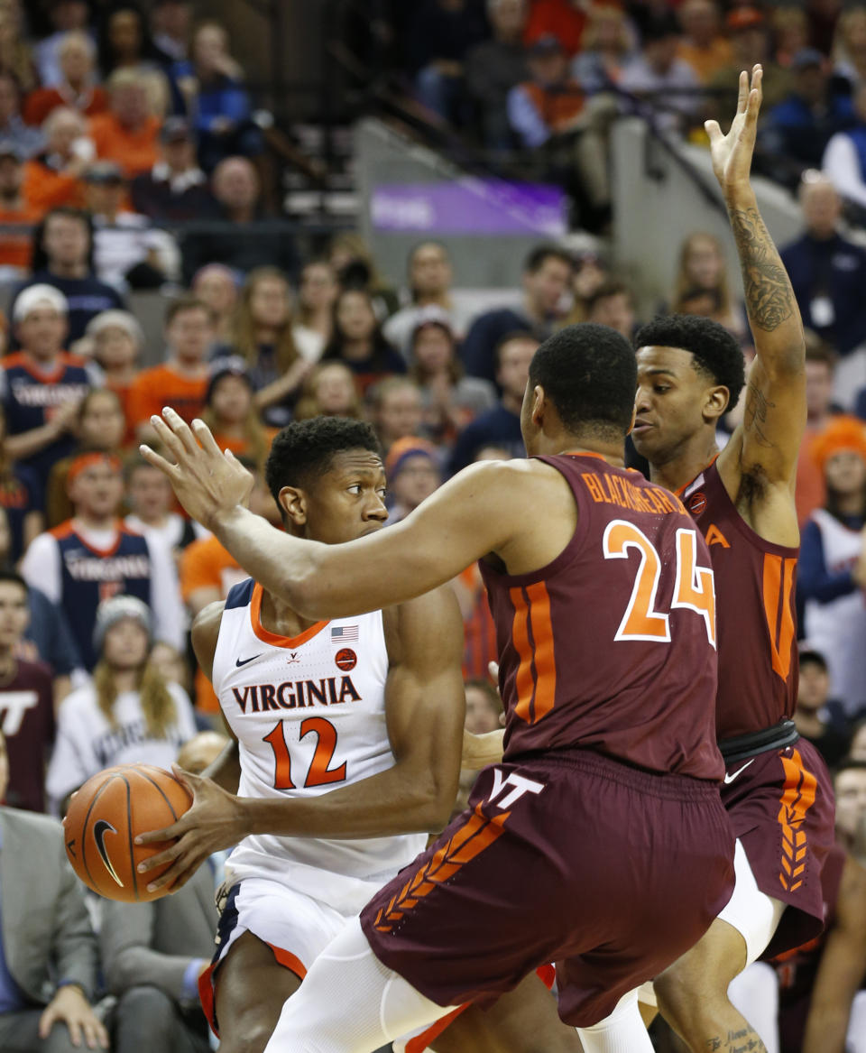 Virginia Tech forward Kerry Blackshear Jr. (24) and Virginia Tech guard Nickeil Alexander-Walker, right, press Virginia guard De'Andre Hunter (12) during the first half of an NCAA college basketball game in Charlottesville, Va., Tuesday, Jan. 15, 2019. (AP Photo/Steve Helber)