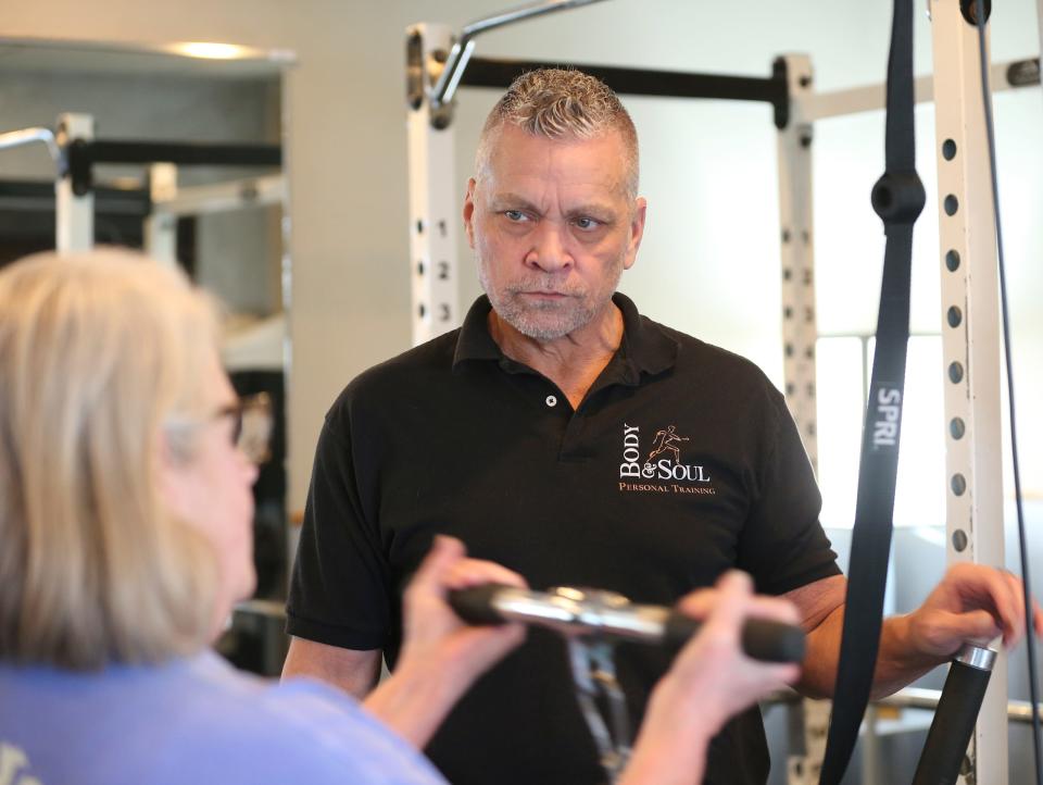 Bruce Miller, owner of Body & Soul, works with Barbara Davies during her workout.