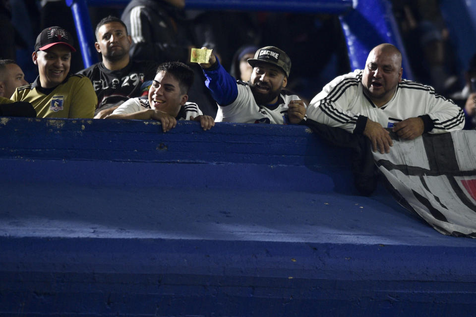 FILE - A Chile's Colo-Colo soccer fan holds out Argentine banknotes taunting Argentina's Boca Juniors fans, ahead of a Copa Libertadores soccer match in Buenos Aires, Argentina, June 6, 2023. The Argentine pesos are becoming a target of disdain from its neighbors. Brazilian soccer fans have torn up peso bills as a mockery to their Argentine rivals. In Paraguay, exchange offices have begun to reject Argentine pesos. (AP Photo/Gustavo Garello, File)