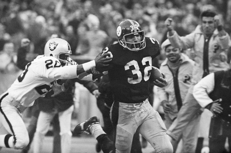 FILE - In this Dec. 23, 1972, file photo, Pittsburgh Steelers' Franco Harris (32) eludes a tackle by Oakland Raiders' Jimmy Warren as he runs 42-yards for a touchdown after catching a deflected pass during an AFC Divisional NFL football playoff game in Pittsburgh. Harris’ scoop of a deflected pass and subsequent run for the winning touchdown _ forever known as the “Immaculate Reception” _ has been voted the greatest play in NFL history. A nationwide panel of 68 media members chose the Immaculate Reception as the top play with 3,270 points and 39 first-place votes. (AP Photo/Harry Cabluck, File)