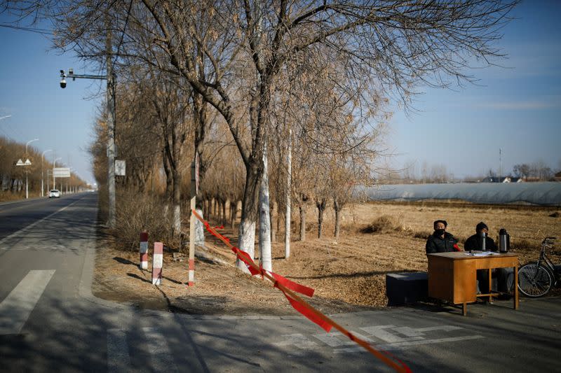 Community members guard at the entrance of a community to prevent outsiders from entering, as the country is hit by an outbreak of the new coronavirus, on the outskirts of Beijing