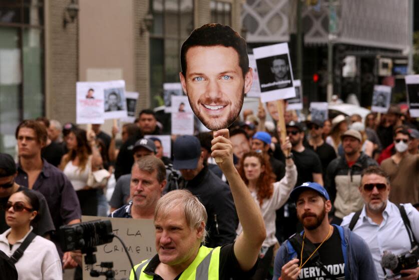 LOS ANGELES, CA - JUNE 12, 2024 - Actor Kevin Suscavage, holding a picture of actor Johnny Wactor, marches with more than one hundred friends, actors and family who marched to City Hall to call for justice in the shooting death of Wactor and urge city officials to post a reward for information leading to the arrest of the killers on June 12, 2024. Wactor, 37, was shot early around 3:30 a.m. May 25 while walking with a co-worker toward his parked car near Hope Street and Pico Boulevard after finishing his bartending shift at the nearby Level 8 bar/restaurant. Police said the pair encountered a crew of people trying steal the catalytic converter from Wactor's car, and one of them shot Wactor as he approached. Wactor formally starred in, "General Hospital," the NBC series, "Siberia," and the HBO series, "Westward." (Genaro Molina/Los Angeles Times)