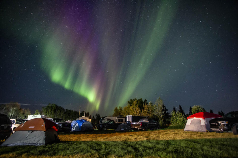 Evacuees from Yellowknife, territorial capital of the Northwest Territories, are greeted with the Aurora Borealis as they arrive to a free campsite provided by the community in High Level, Alta., Friday, Aug. 18, 2023. (Jason Franson /The Canadian Press via AP)