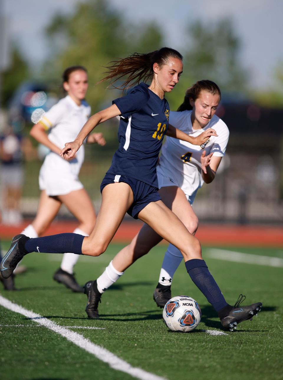 Haslett's Audrey Archambault, left, takes a shot and scores against DeWitt's Marissa Montgomery, Thursday, June 2, 2022, at Eastern High School. Haslett won 8-0.