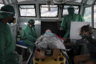 Fluvial emergency workers transfer by boat a 10-year-old suspected COVID-19 patient from a riverside community to a hospital in Manaus, Brazil, Friday, May 22, 2020. The youth had fever and other symptoms for three days and had not yet been tested for the new coronavirus. (AP Photo/Felipe Dana)