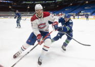 Montreal Canadiens right wing Joel Armia (40) fights for control of the puck with Vancouver Canucks defenseman Quinn Hughes (43) during first-period NHL hockey game action in Vancouver, British Columbia, Monday, March 8, 2021. (Jonathan Hayward/The Canadian Press via AP)