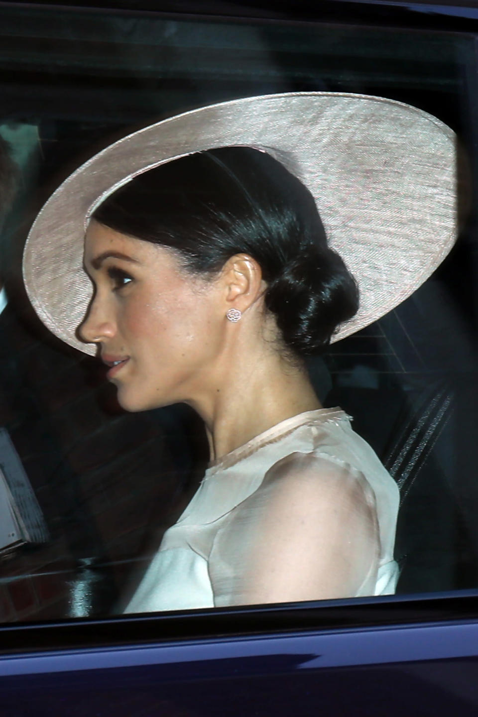 The Duchess of Sussex wears a bespoke hat by Philip Treacy. [Photo: Getty]