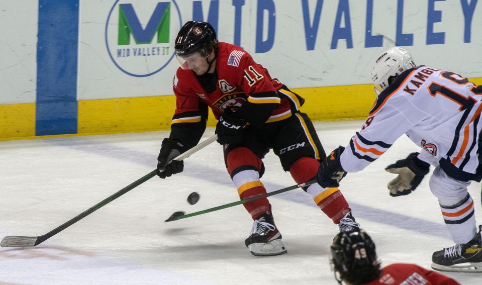 Stockton Heat's Matthew Phillips, left, fights for the puck with Bakersfield Condors' Dino Kambeitz during the second game of the Calder Cup playoffs.