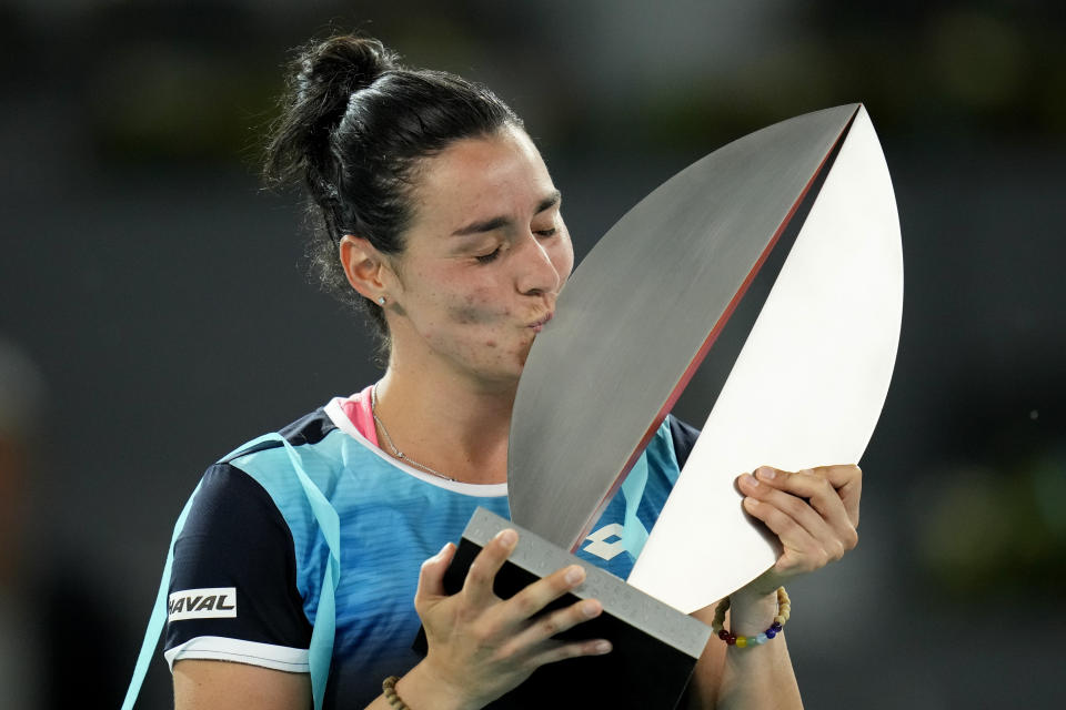 FILE - Ons Jabeur kisess the winner's trophy at the end of the women's final at the Madrid Open tennis tournament in Madrid, Spain, Saturday, May 7, 2022. Jabeur willl compete in the 2022 Wimbledon tennis tournament. (AP Photo/Manu Fernandez, File)