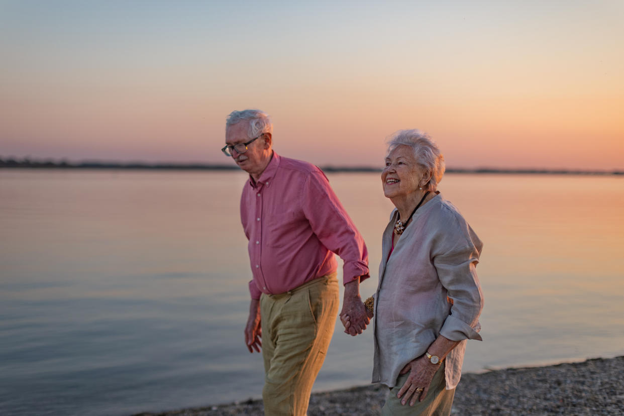 A senior couple enjoying summer vacation by the sea, celebrating their wedding anniversary. Pensioners spending a romantic summer by the lake, exploring new places and traveling. Concept of traveling in retirement. dementia