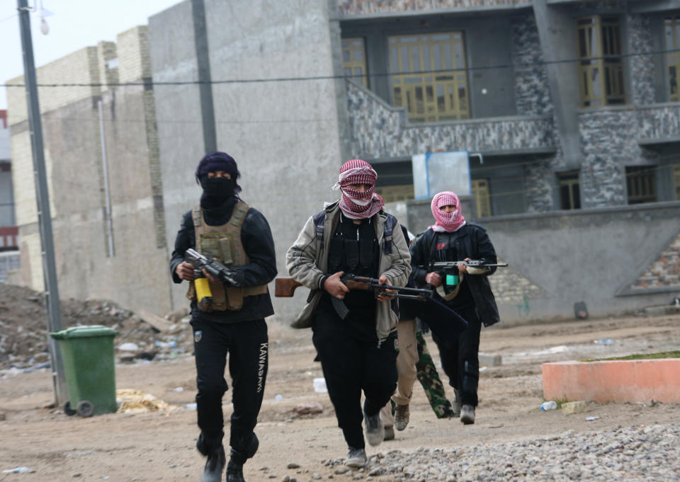 Gunmen patrol during clashes with Iraqi security forces in Fallujah, 40 miles (65 kilometers) west of Baghdad, Iraq, Sunday, Jan. 5, 2014. Lt. Gen. Rasheed Fleih, who leads the Anbar Military Command, told the state television Sunday that "two to three days" are needed to push the militants out of Fallujah and parts of Ramadi. (AP Photo)