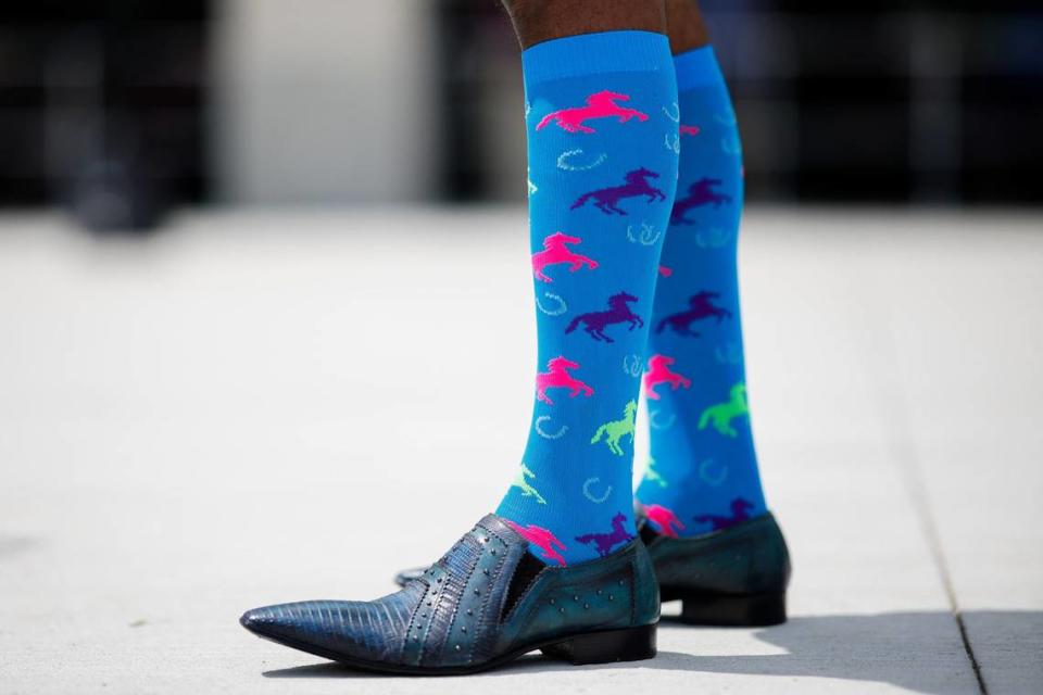 A spectator wearing horse themed socks waits near the paddock before the 150th running of the Kentucky Derby at Churchill Downs in Louisville, Ky., on Saturday, May 4, 2024.