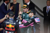First place, Red Bull driver Max Verstappen of the Netherlands, left, celebrates on the podium with second place, Aston Martin driver Fernando Alonso of Spain, center, and third place, Alpine driver Esteban Ocon of France at the finish of the Monaco Formula One Grand Prix, at the Monaco racetrack, in Monaco, Sunday, May 28, 2023. (AP Photo/Luca Bruno)