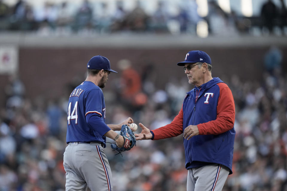 Texas Rangers pitcher Andrew Heaney, left, hands the ball over to manager Bruce Bochy while being pulled during the second inning of a baseball game against the San Francisco Giants, Saturday, Aug. 12, 2023, in San Francisco. (AP Photo/Godofredo A. Vásquez)