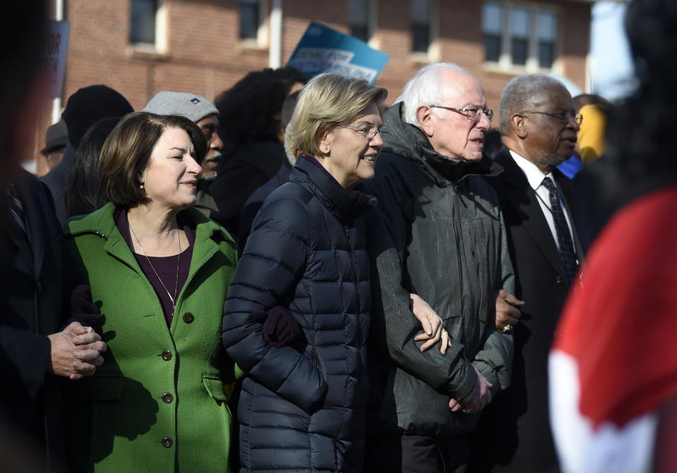 Democratic presidential rivals Amy Klobuchar, Elizabeth Warren and Bernie Sanders link arms during a Martin Luther King Jr. Day march on Monday, Jan. 20, 2020, in Columbia, S.C. (AP Photo/Meg Kinnard)