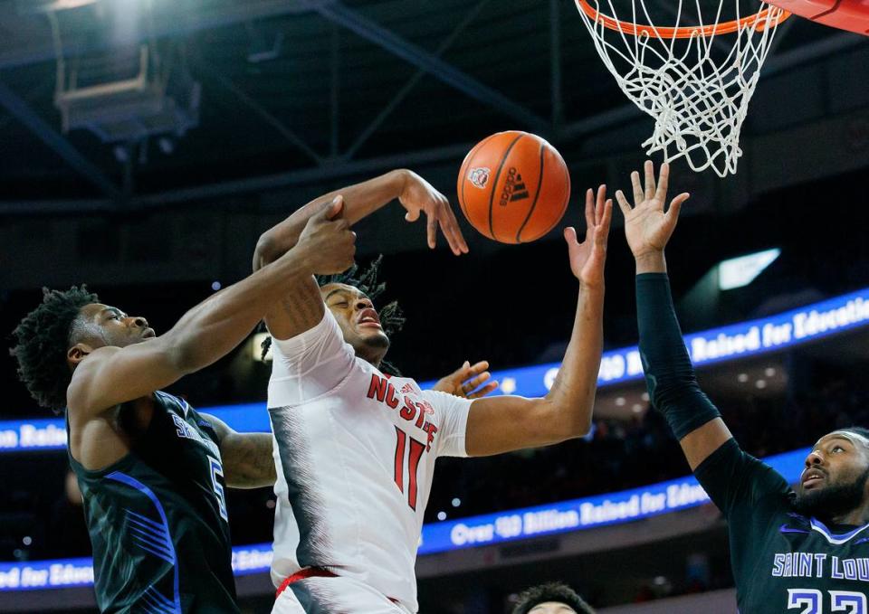 N.C. State’s Dennis Parker Jr. battles for a rebound with Saint Louis’ Tim Dalger (5) and Terrence Hargrove Jr. (22) during the first half of the Wolfpack’s game on Wednesday, Dec. 20, 2023, at PNC Arena in Raleigh, N.C.