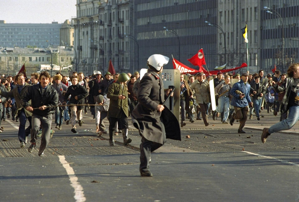 FILE - A militiaman is chased by a mob of hard-liners who forced their way through police blocks when making their way to the Russian White House in Moscow, on Oct. 3, 1993. The October 1993 violent showdown between the Kremlin and supporters of the rebellious parliament marked a watershed in Russia's post-Soviet history. (AP Photo/Alexander Zemlianichenko, File)