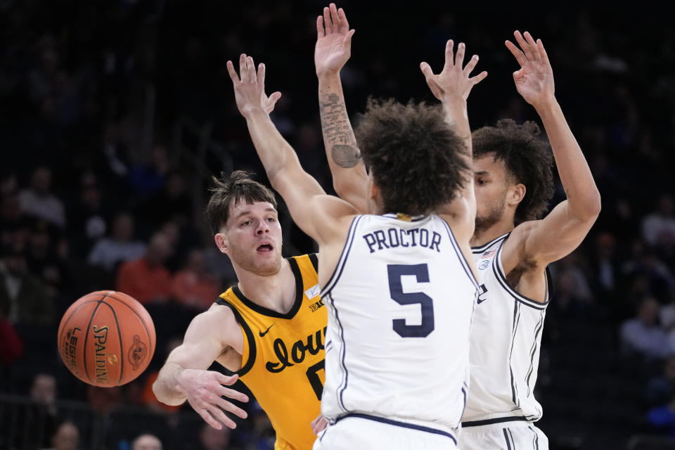Iowa's Filip Rebraca (0) passes around Duke's Tyrese Proctor (5) during the second half of an NCAA college basketball game in the Jimmy V Classic, Tuesday, Dec. 6, 2022, in New York. (AP Photo/John Minchillo)
