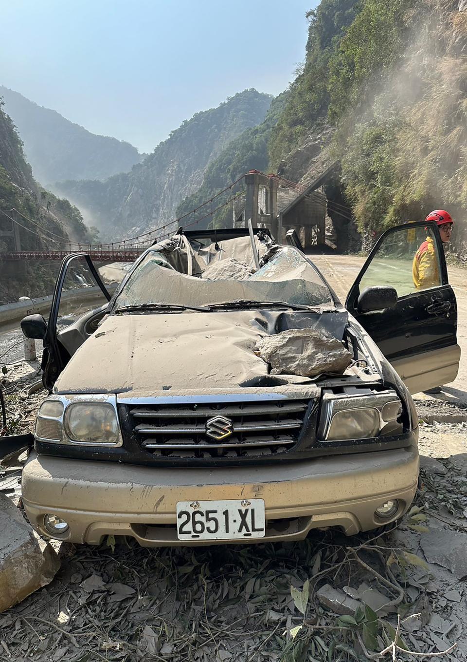 This handout from the Hualien Fire Department taken and released on April 3, 2024 shows a car and bridge (background) damaged in Hualien, after a major earthquake hit Taiwan's east. At least seven people were killed and more than 700 injured on April 3 by a powerful earthquake in Taiwan that damaged dozens of buildings and prompted tsunami warnings that extended to Japan and the Philippines before being lifted.