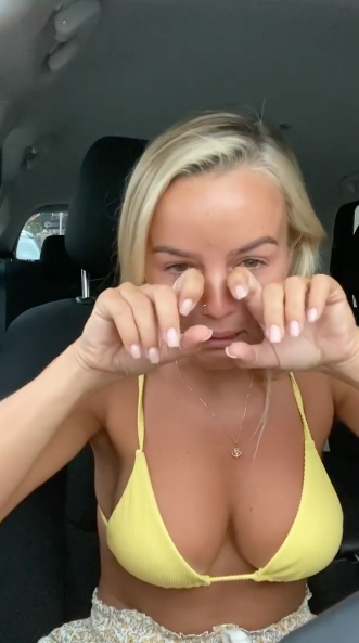 Bachelorette Elly Miles wearing a yellow bikini top and crying in her car while announcing her breakup with Frazer Neate