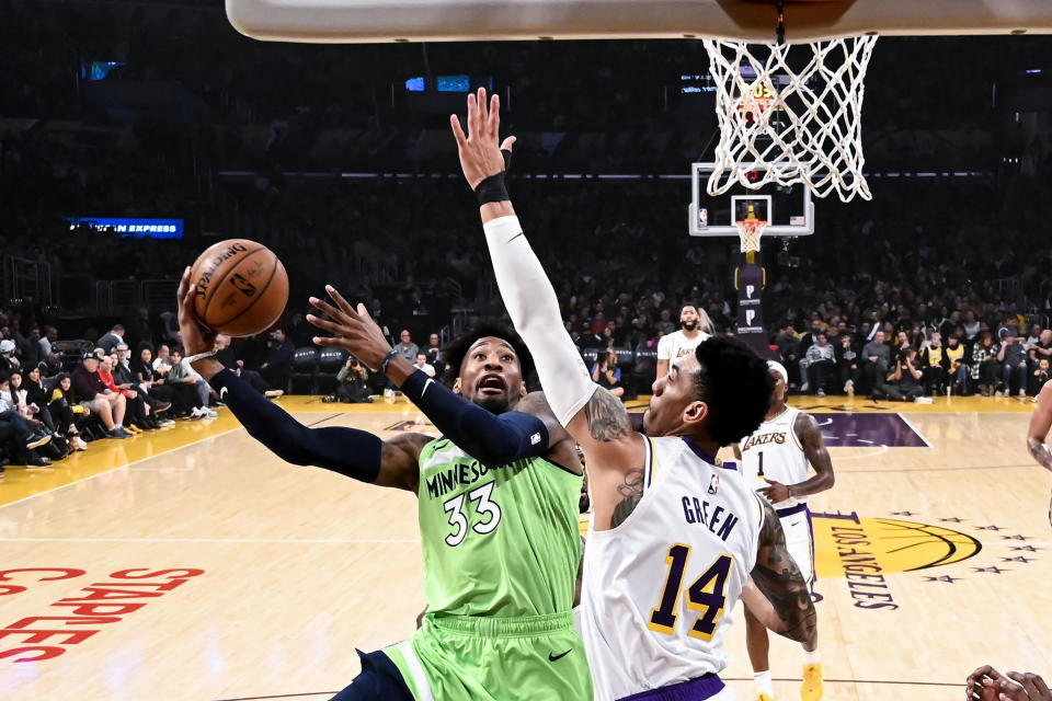 Minnesota Timberwolves' Robert Covington (33) goes to basket under pressure from Los Angeles Lakers' Danny Green (14) during the first half of an NBA basketball game, Sunday, Dec. 8, 2019, in Los Angeles. (AP Photo/Ringo H.W. Chiu)
