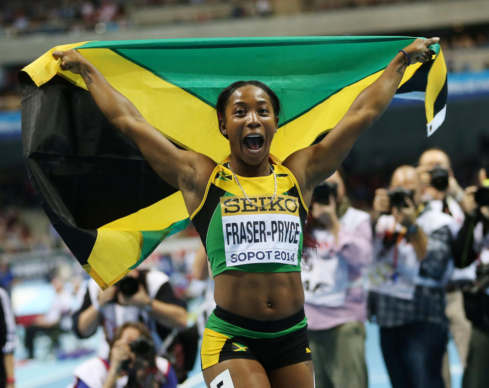 Jamaica's Shelly-Ann Fraser-Pryce carries the national flag after winning the 60m final during the Athletics World Indoor Championships in Sopot, Poland, Sunday, March 9, 2014. (AP Photo/Petr David Josek)