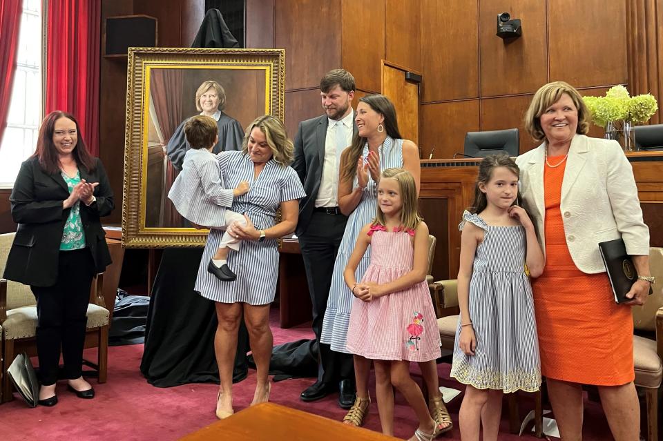 State Supreme Court Justice Sharon Lee, right, hugs granddaughter Grace Chermely after an unveiling of her portrait in the Tennessee Supreme Court Building on Aug. 24. Others, from left, are Loretta Cravens, Knoxville Bar Association president; daughter Laura Gregg, holding Sheperd Gregg: Wayne Chermely; daughter Sarah Chermely; and Julia Chermely.