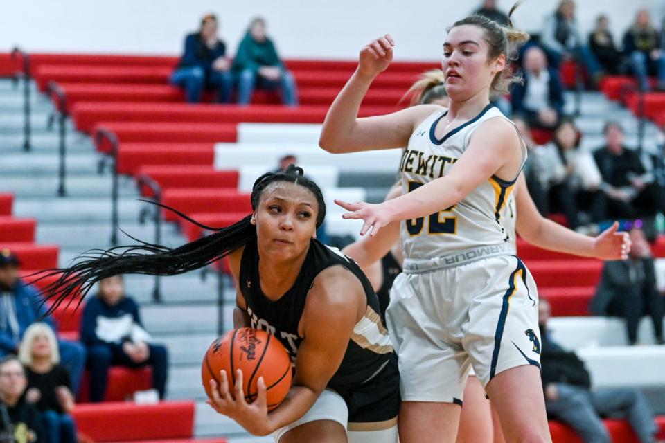 Holt's Janae Tyler, left, pulls down a rebound over DeWitt's Alex Charles during the second quarter on Thursday, March 9, 2023, at Coldwater High School.